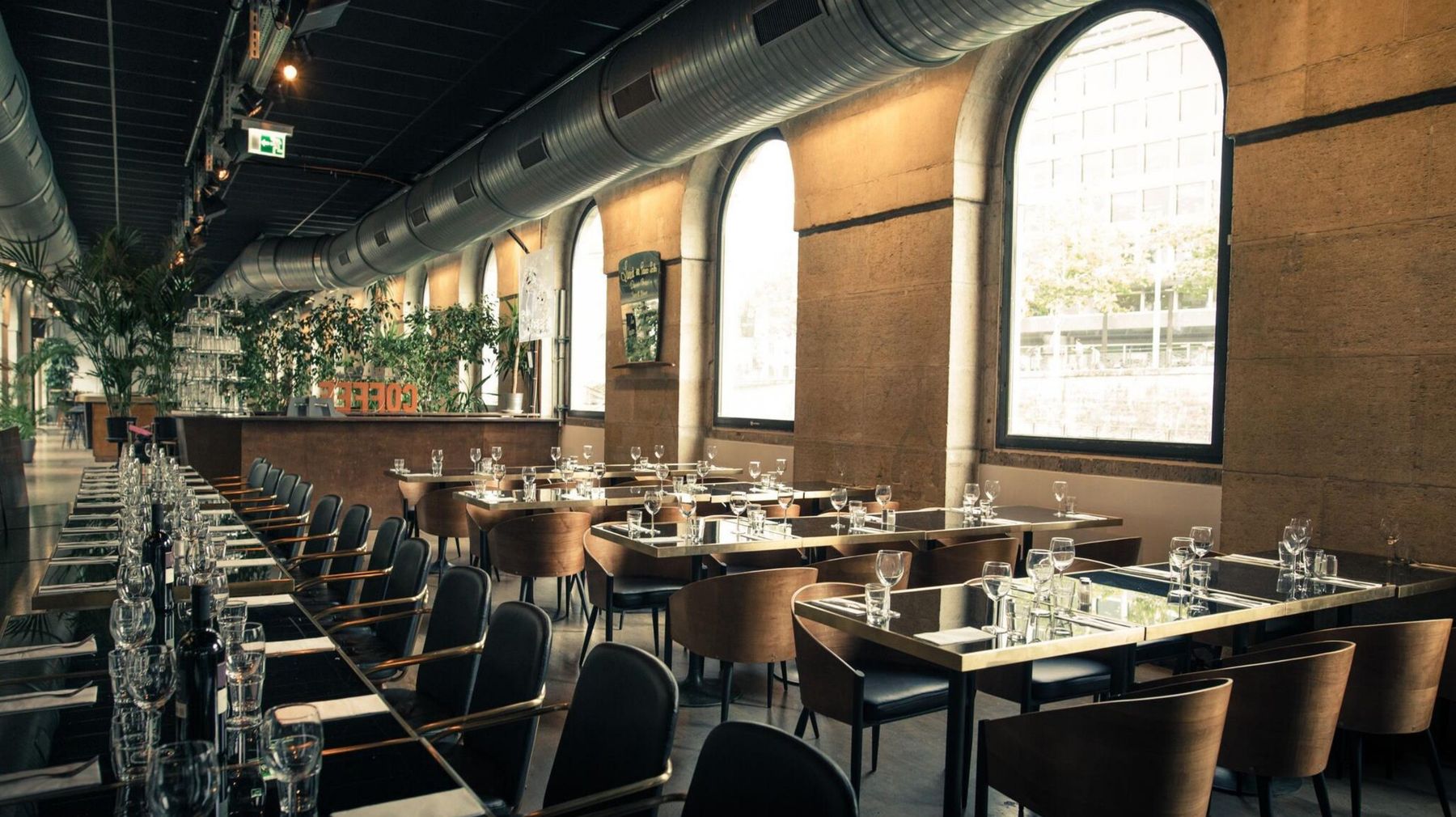 Les Halles de l'Île, Genève : salle à manger aux grandes fenêtres cintrées sur le Rhône