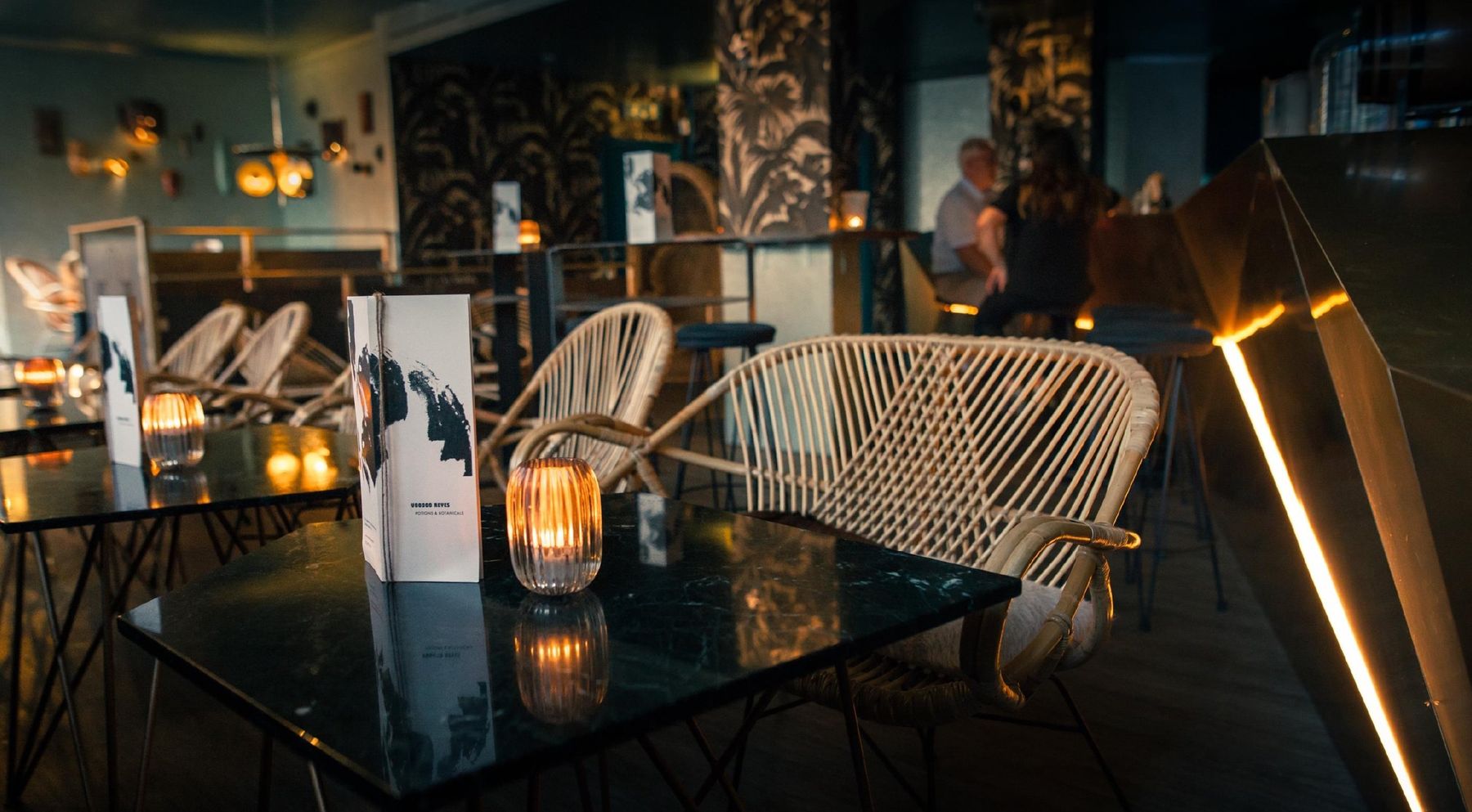 Voodoo Reyes, Genève : fauteuils en rotin et tables à la bougie